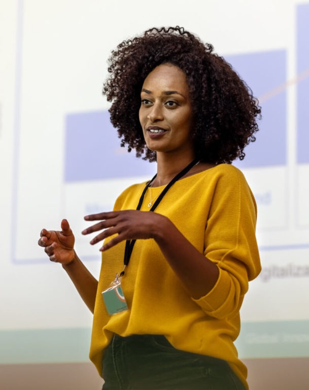 Woman presenting slides in front of a room