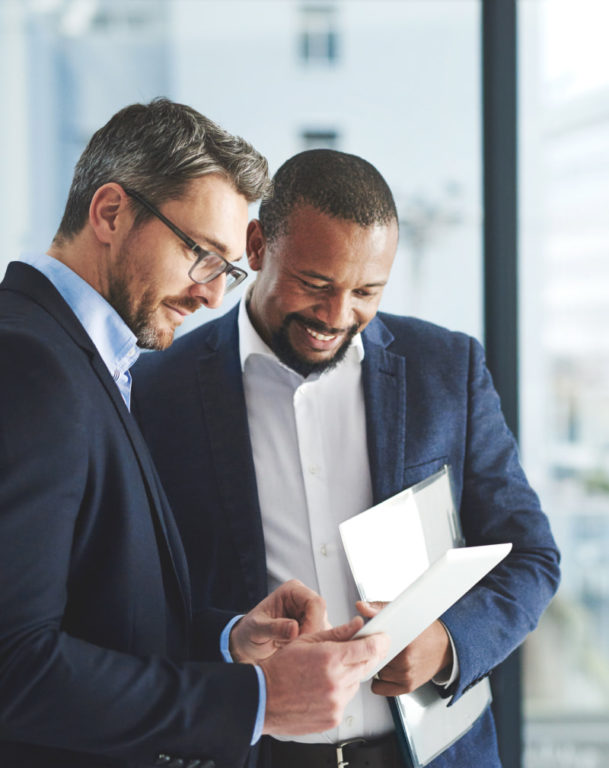 Two businessmen using a digital tablet together at work
