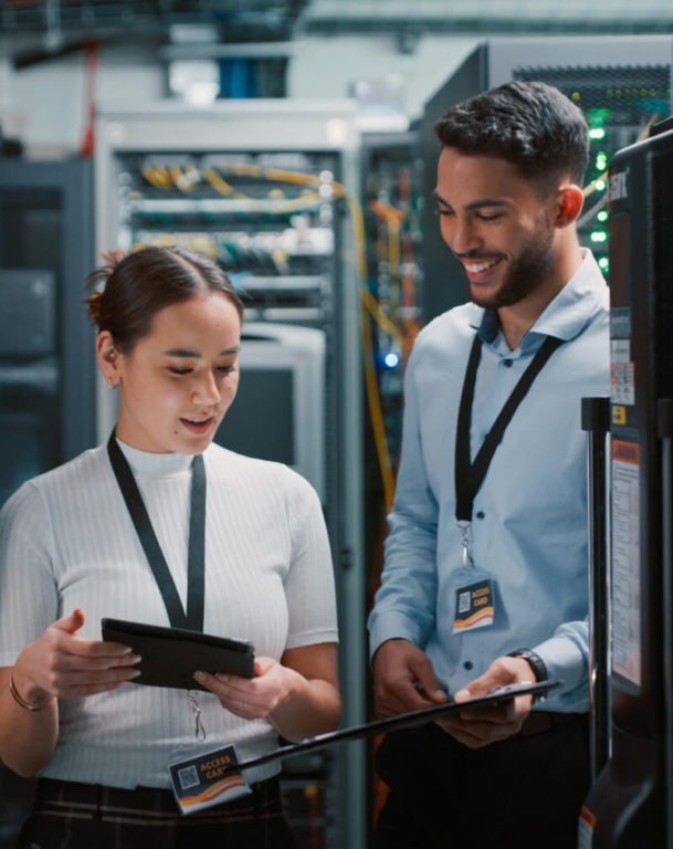 Two coworkers looking at a tablet in a data center