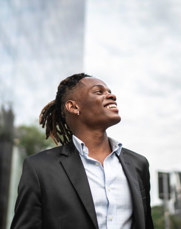 Man in suit looking at the sky with skyscrapers in the background