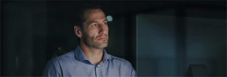 Man working in dark office on a desktop computer