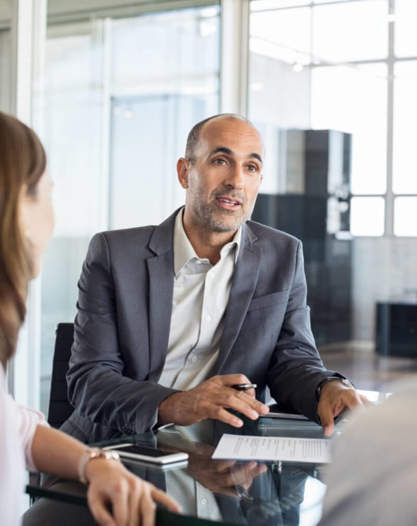 Man talking to clients at an office table