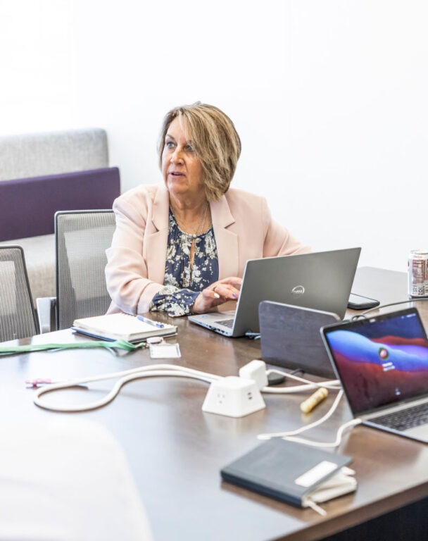 Woman sitting in front of laptop looking to the left