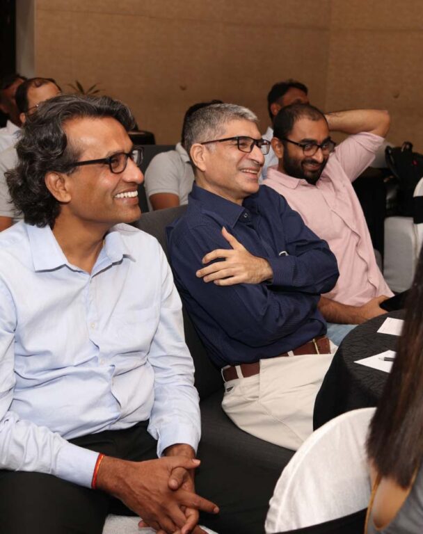 Ensono employees sitting in a row laughing at a conference