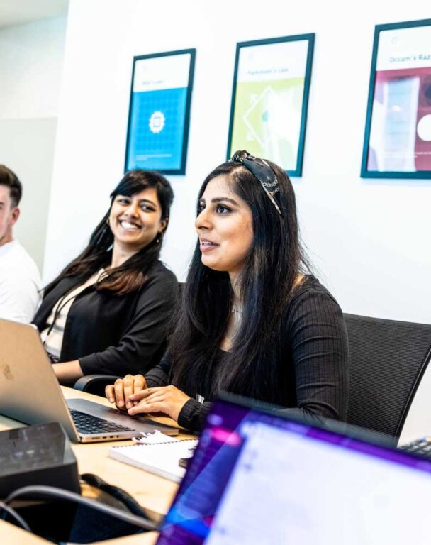 Two people working at a computer in a conference room