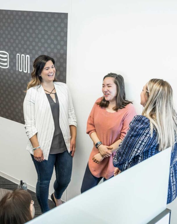 Three coworkers talking in hallway