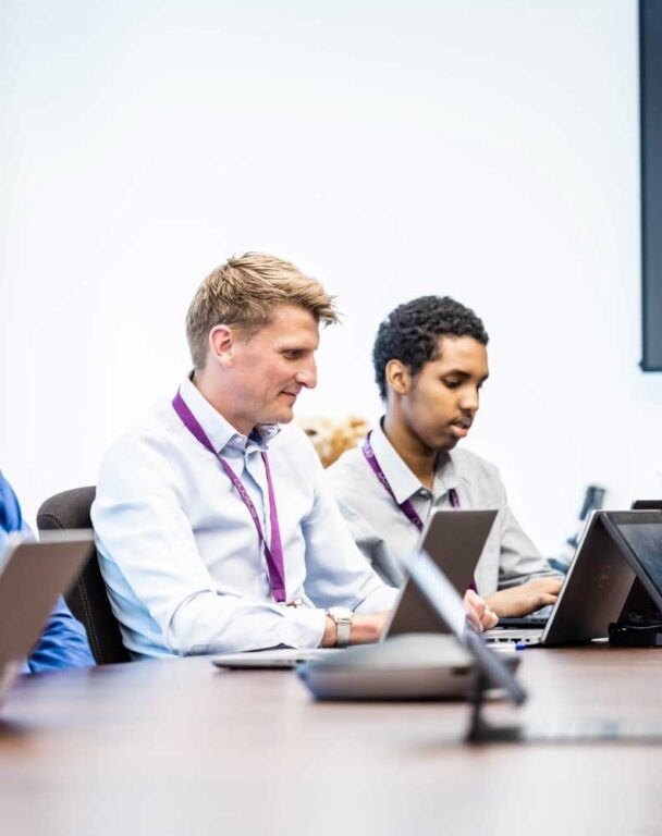 Two Ensono coworkers sitting at conference table