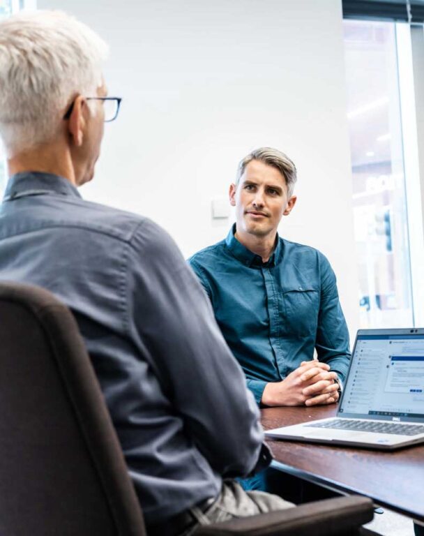 Ensono employees talking at desk