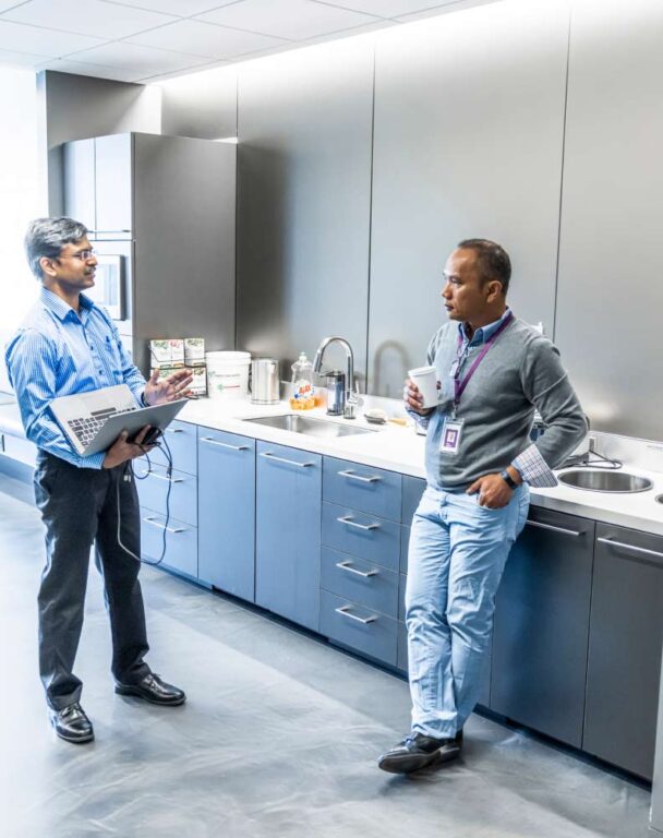 Two coworkers talking in office kitchen