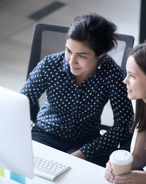 Two employees looking at a laptop screen