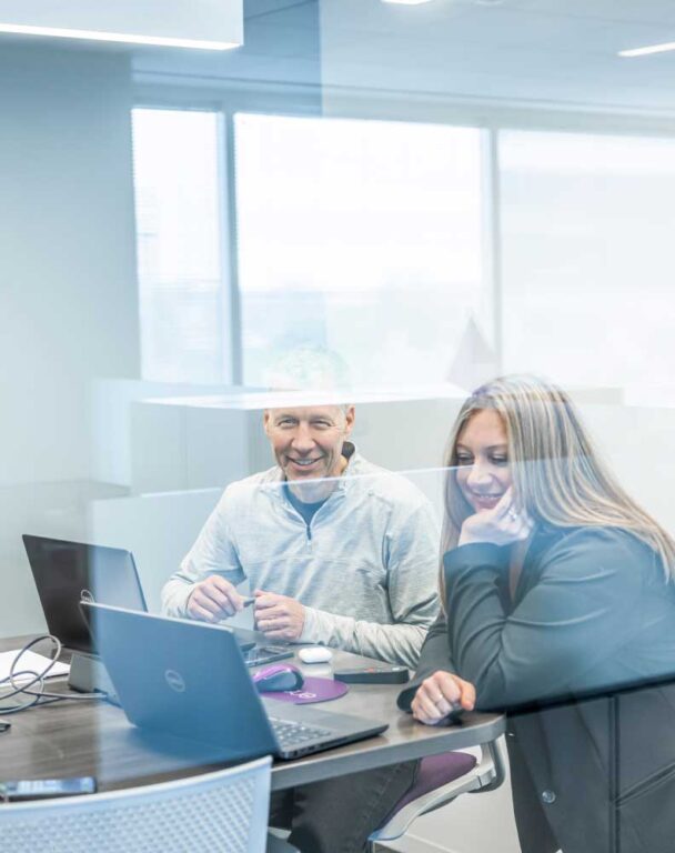 Ensono employees in a glass conference room