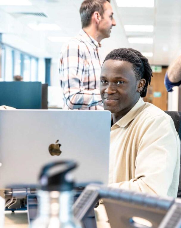 Ensono employee looking at laptop