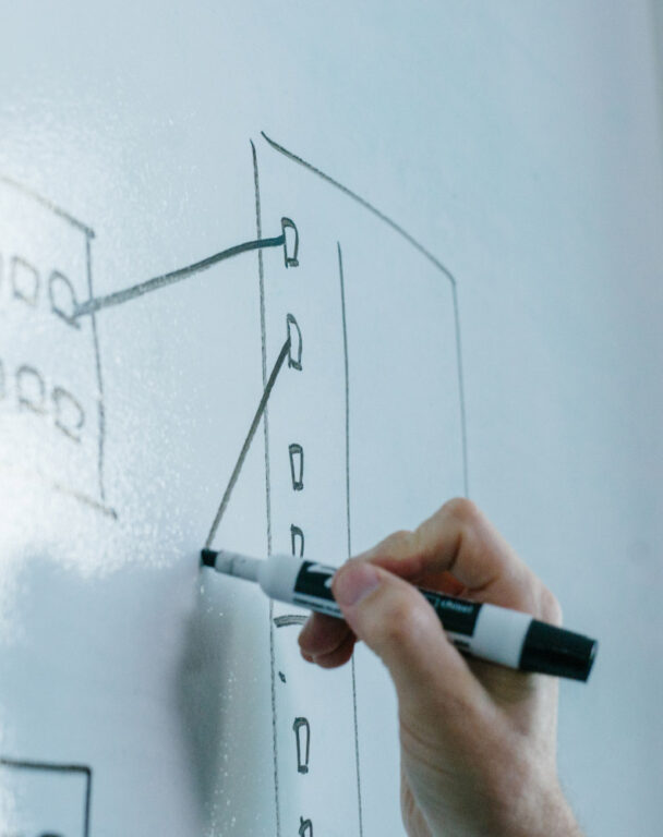 Person drawing on white board with marker