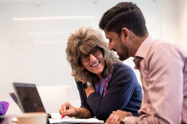 Manager and associate talking at desk